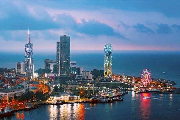 Batumi seafront skyline at twilight with illuminated towers and the Ferris wheel