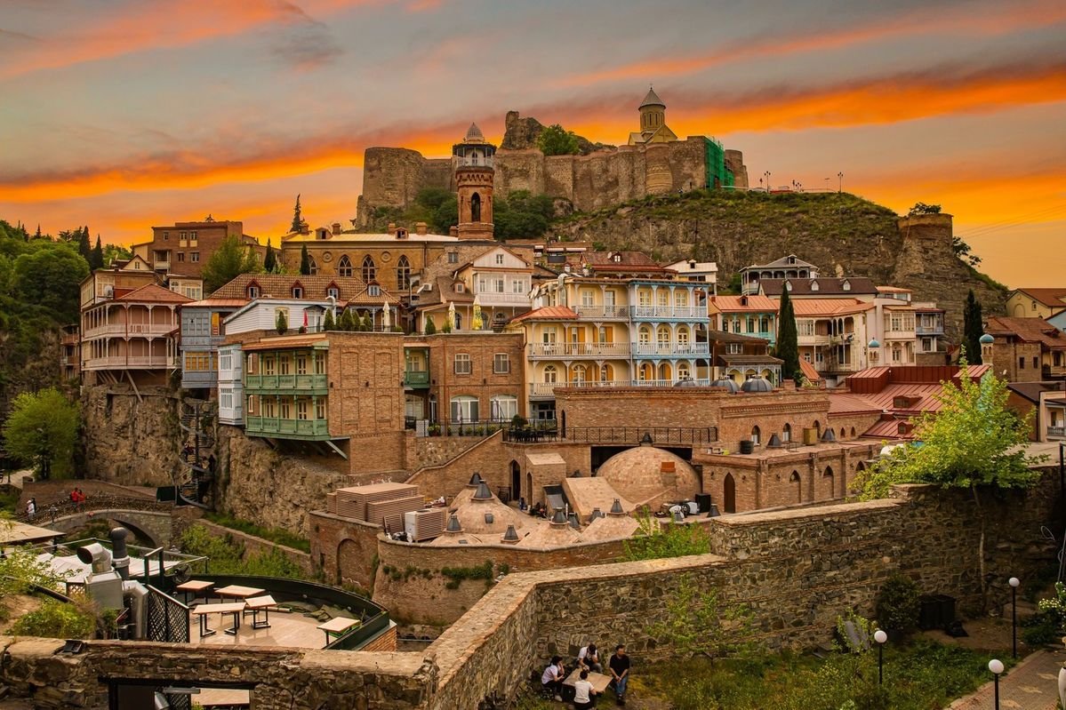 Tbilisi old town glowing at sunset over the Mtkvari river